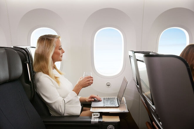 Woman enjoying extra legroom in Premium Economy on Qantas Dreamliner